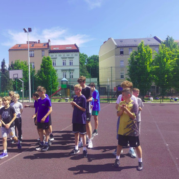 Grupa uczniów stojących w trójszeregu podczas rozgrzewki