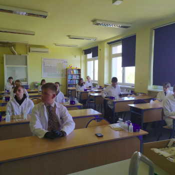 Grupa uczniów w ławkach w pracowni chemicznej