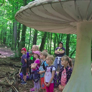 grupa uczniów przy posągu grzyba